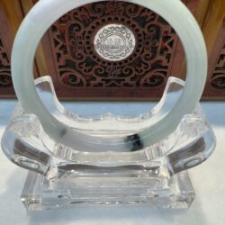 Milky green jade bangle on acrylic display