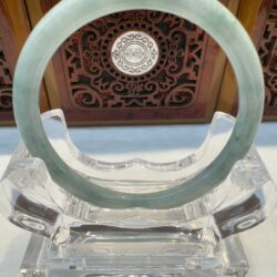 Polished jade bangle perched on crystal stand