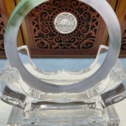 Light green jade ring before carved panel