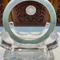 Green jade bangle front-facing on crystal display