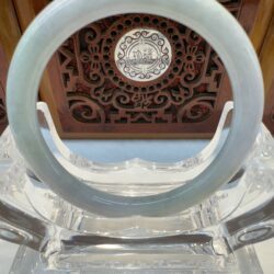 Pale gray jade bangle with carved backdrop