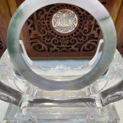 Polished green jade bracelet with carved panel