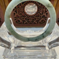 Mottled green jade bangle on stand