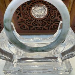 Translucent jade bangle on clear acrylic stand