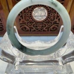 Translucent green jade bangle on crystal stand
