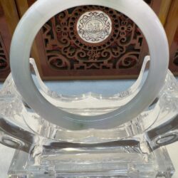 Crystal and jade circular ornament on stand.