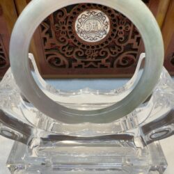 Crystal ring on ornate wooden stand.