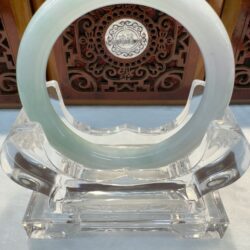 Round pale jade bracelet displayed on pedestal