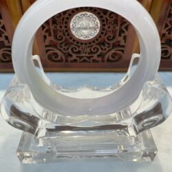 White jade bracelet with carved wooden backdrop
