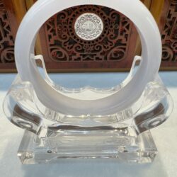 Translucent white jade bangle on crystal stand