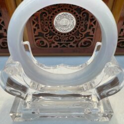 White jade ring on decorative stand.