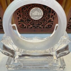 Translucent white jade bangle on crystal stand