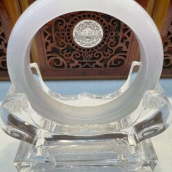 White jade bangle on clear acrylic stand
