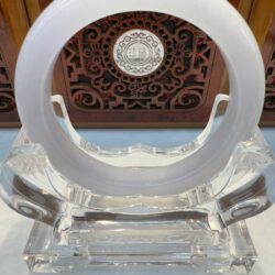 Translucent circular jade ring on acrylic base