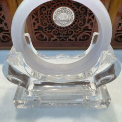 Clear glass stand with circular frame.