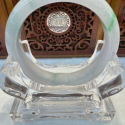 Jade bangle with carved wooden backdrop