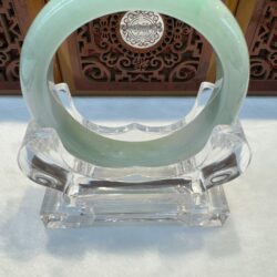 Smooth light green jade bangle on stand
