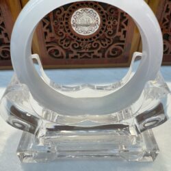 White jade ring on clear display stand