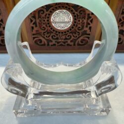 Round green jade bracelet on clear acrylic