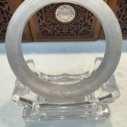 Translucent circular sculpture on a decorative stand.