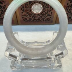 Pale green jade bangle on crystal stand