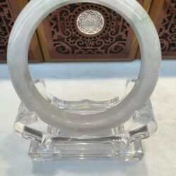 Symmetrical pale jade bangle on clear stand