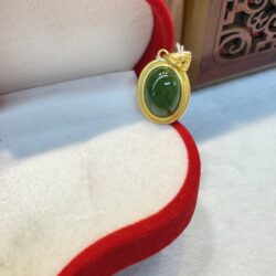 Green gemstone pendant in red jewelry box.