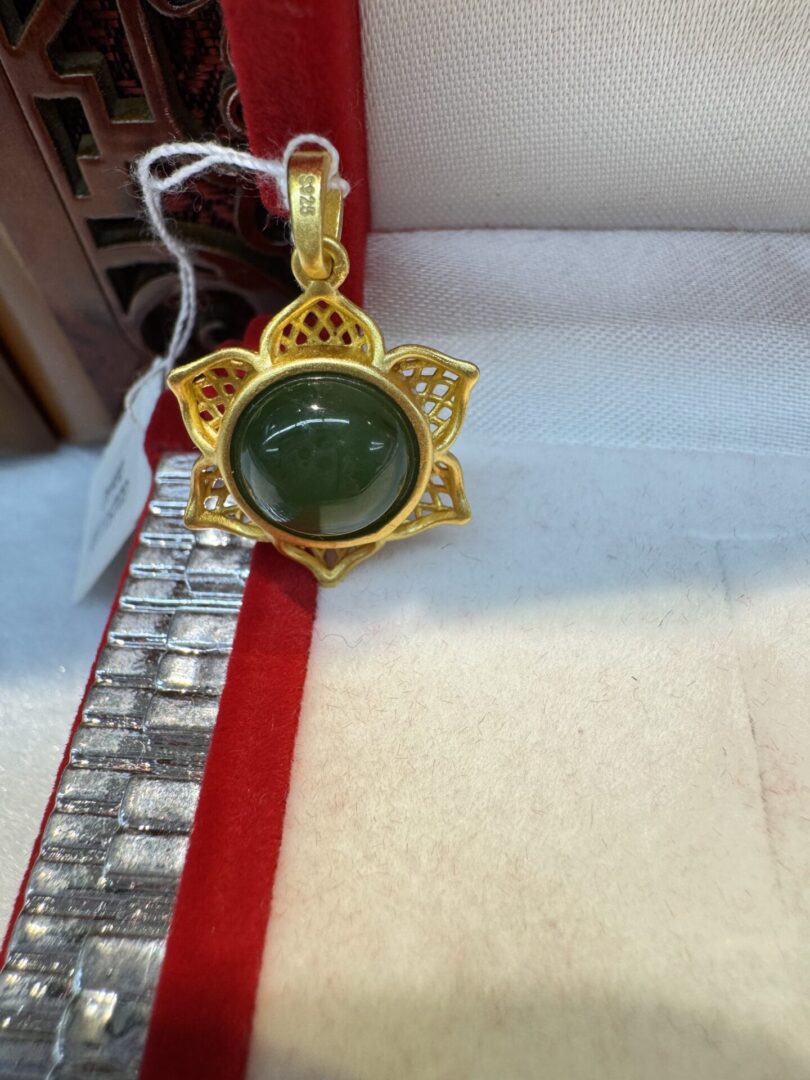 Gold lotus pendant with dark jade cabochon