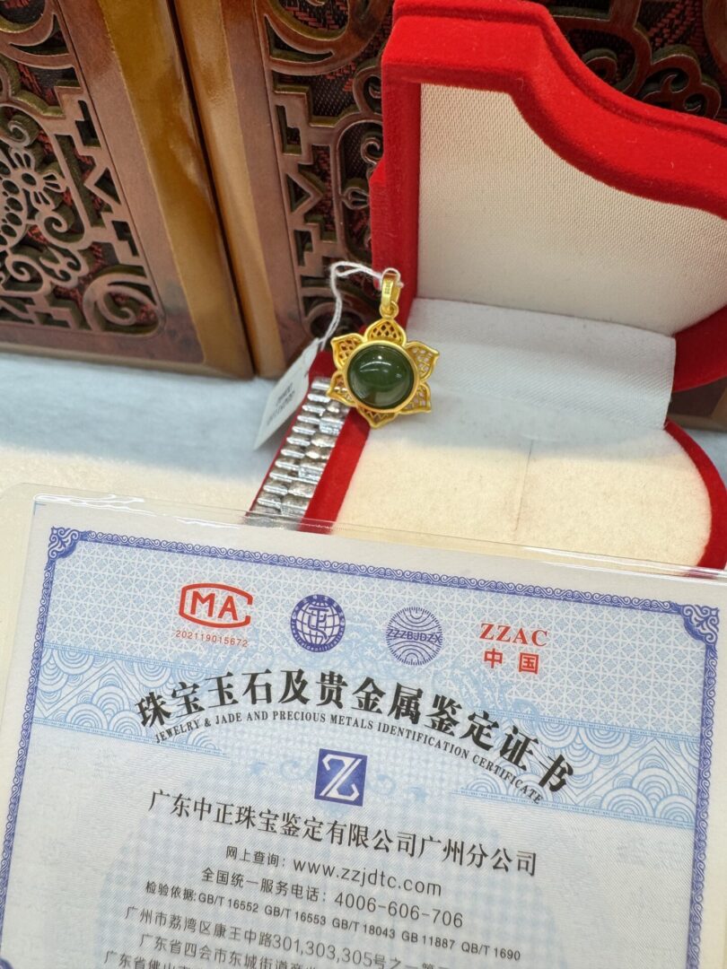 Gold pendant and certificate in a box.
