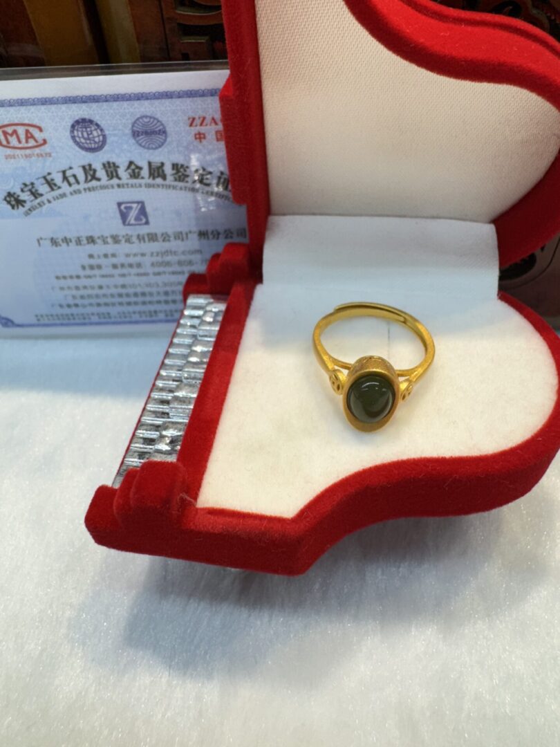 Gold ring in a red jewelry box.