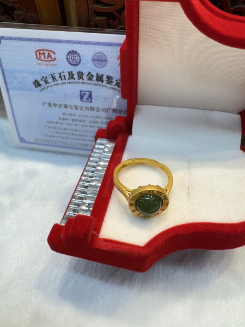 Jade cabochon ring beside certification