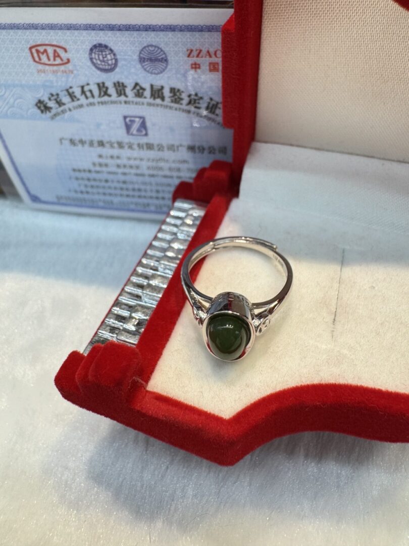 Ring with green cabochon in red heart box