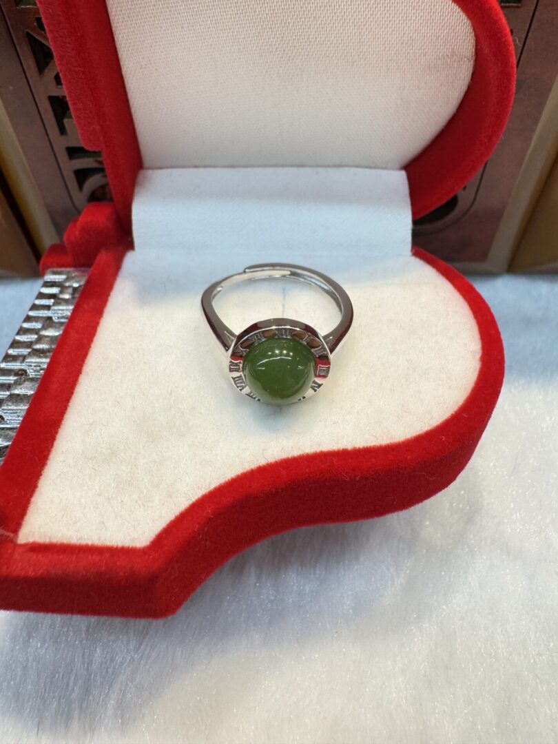 Ring with green stone in red box.