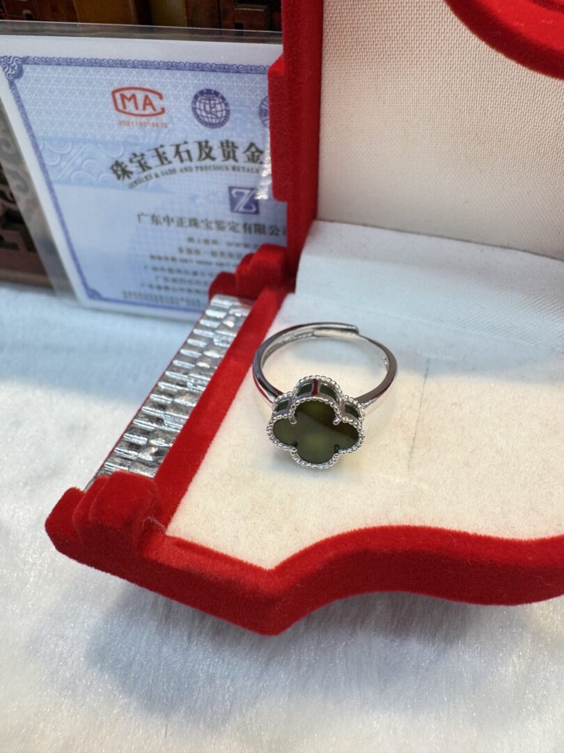 Green clover ring beside authenticity certificate