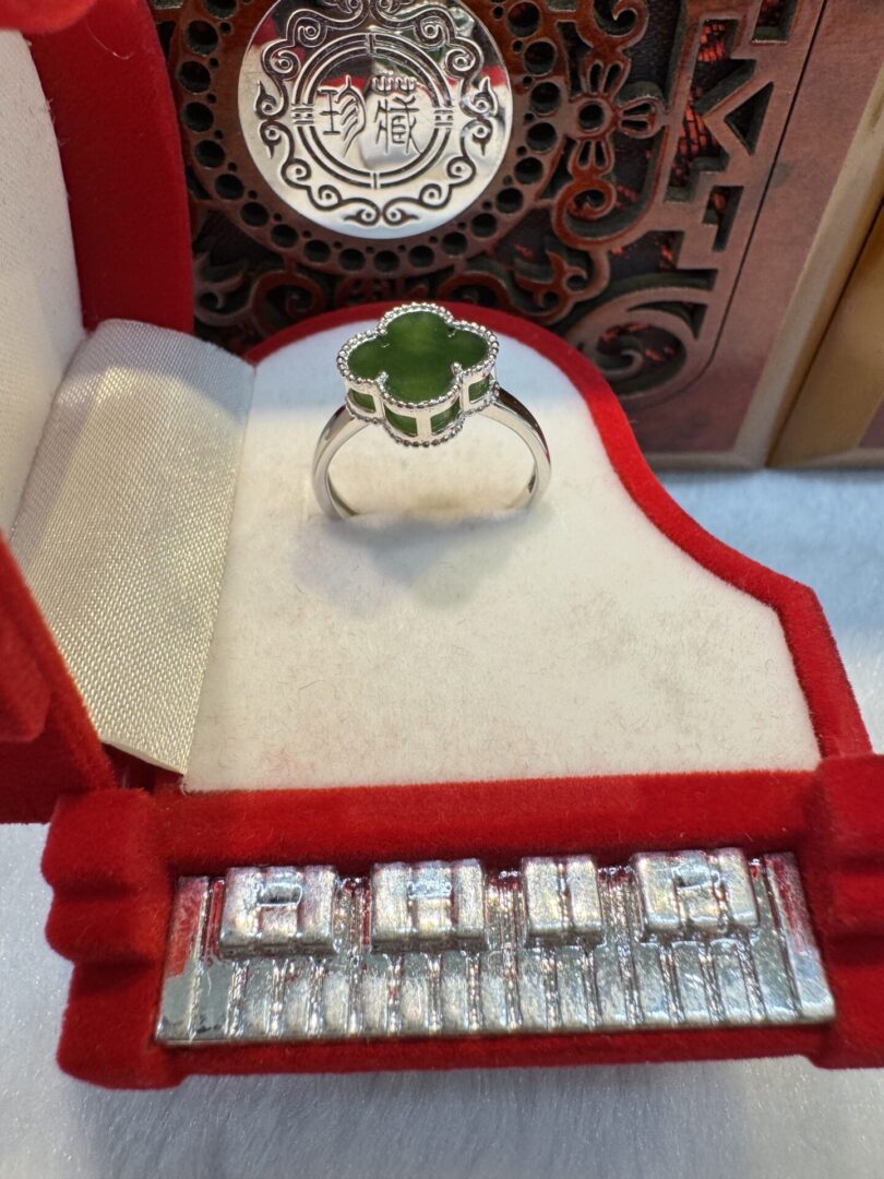 Clover-shaped green jade ring in red box