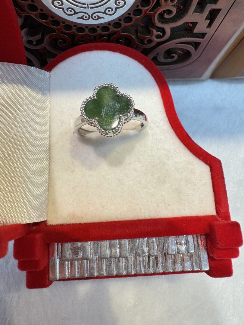 Green clover ring in red jewelry box.