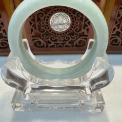 Light celadon jade bangle centered on stand