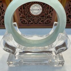 Translucent circular jade bracelet with wood backdrop