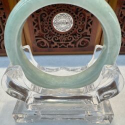 Glossy jade bangle with overhead light reflections