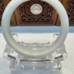 Polished white jade bracelet on crystal stand