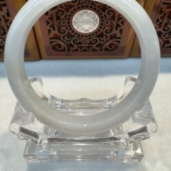 Glossy pale jade bangle on clear display