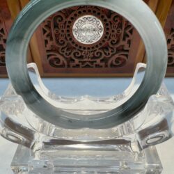 Circular jade ornament on intricate stand.