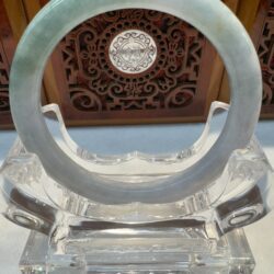 Pale green jade bangle on clear stand