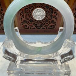Jade circle sculpture with intricate background design.
