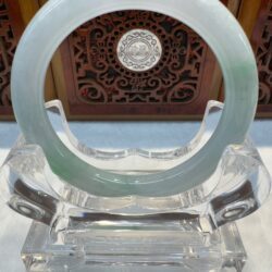 Jade ring on intricate wooden background display.