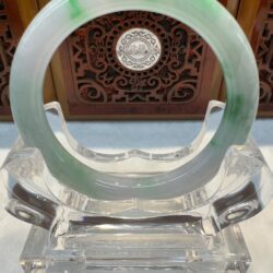 Circular jade bangle on crystal display stand