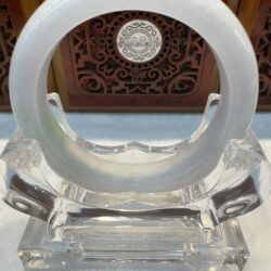 Translucent pale jade bangle on crystal stand