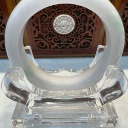 White jade bangle on clear display stand