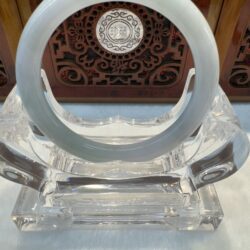 Smooth milky-white jade bangle on display stand
