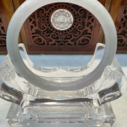 White jade bangle on clear acrylic stand